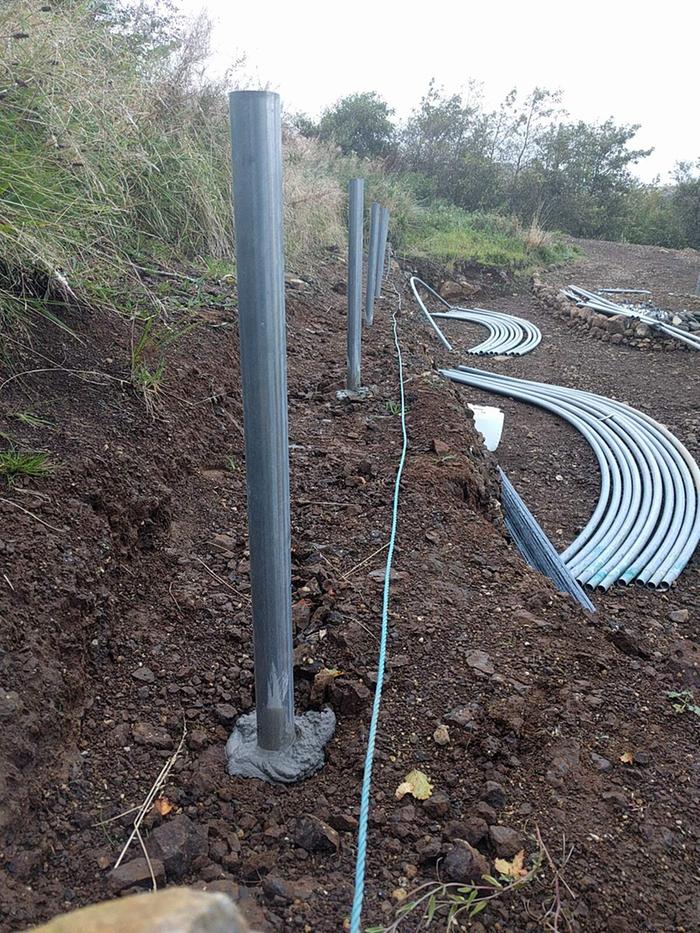 construction of a polytunnel with metal poles set into rock and hoops laid on ground