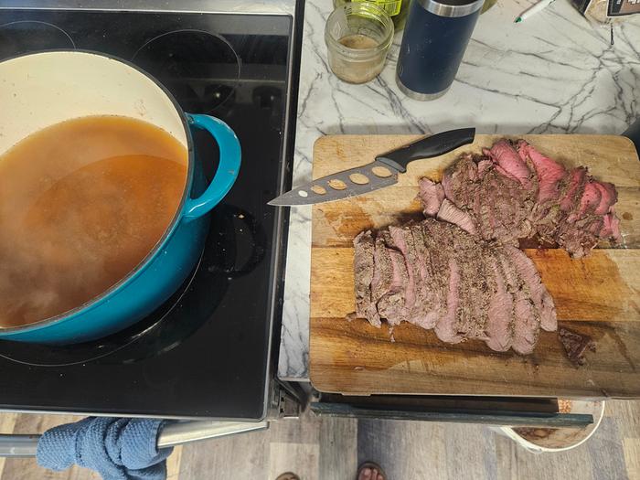 Roast being sliced, aux jus being simmered