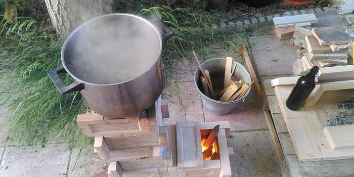 water in a pot being heated on a j tube rocket core