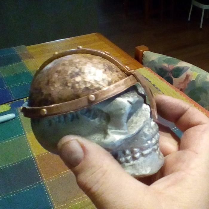 a lost foam cast skull with a bronzed helmet