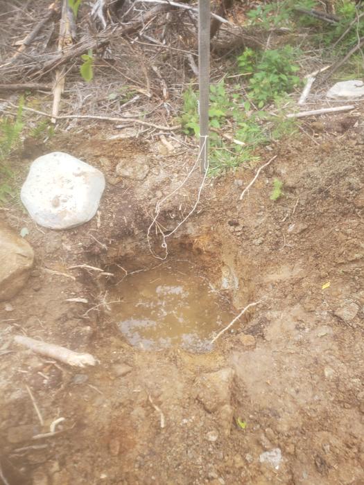 A hole with water in it, also a large white stone