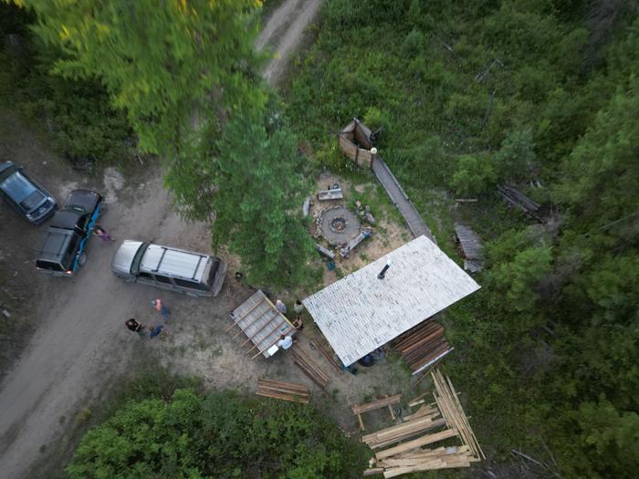 Look at all that lumber behind the sauna! What a perfect hideaway. Also, the wall-tastic wonders working away on the flatbed trailer