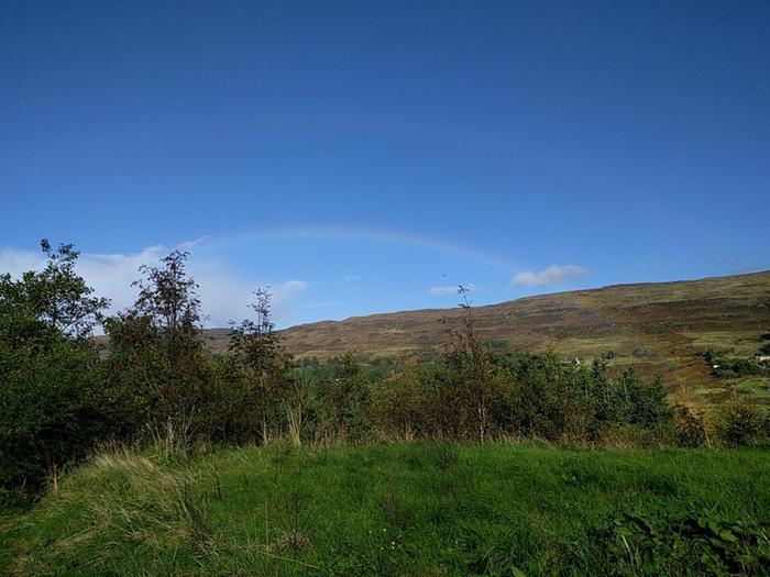 double rainbow against a blue sky on the isle of skye