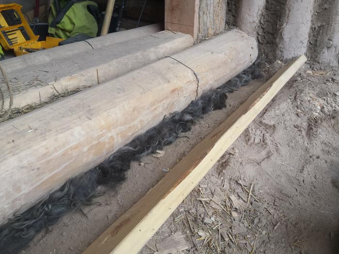 wool stuffed under the support log and behind the 2x6 to continue the insulation layer