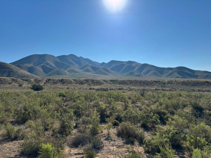 a flat place in mexico in front of some hills