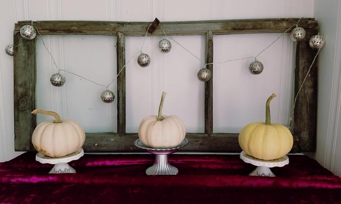 Baby pumpkins on cupcake stands that were gifts on a piece of velvet fabric