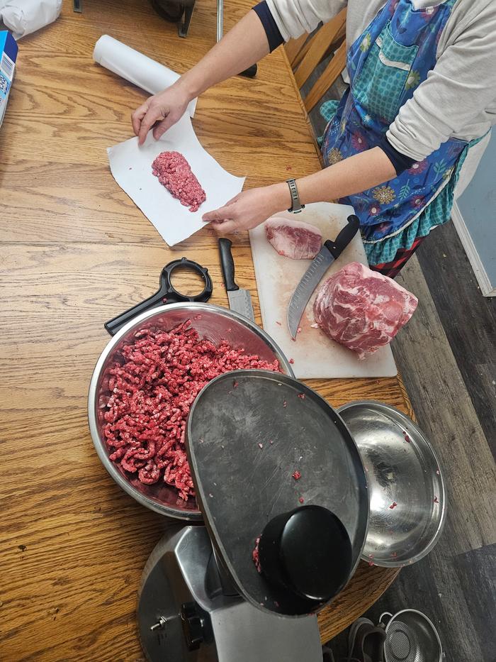 Grinding burger and sausage that I wrapped in butcher paper and froze