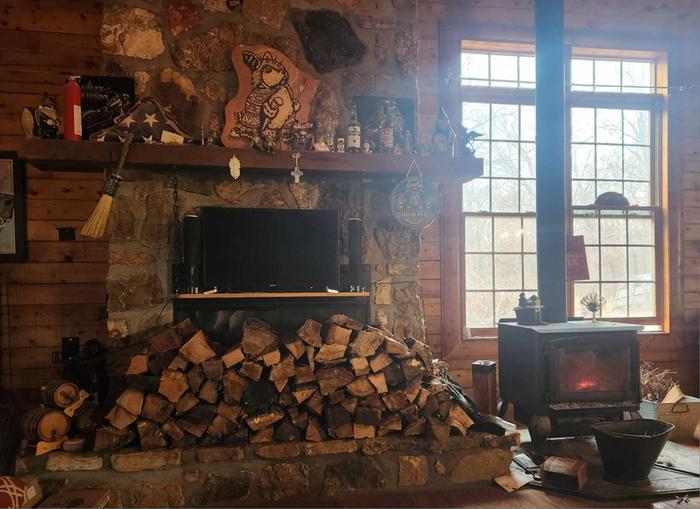 The current setup, the defunct fireplace is now storage for the large amount of wood the stove consumes. 