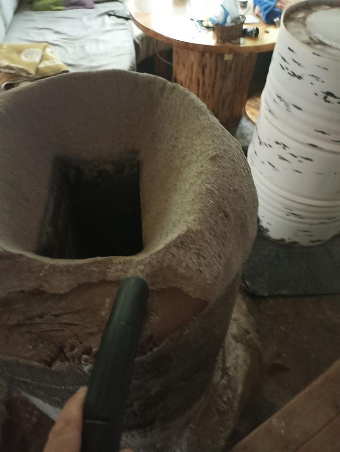 using a vacuum to suck fine fly ash off of the riser of a rocket masonry heater