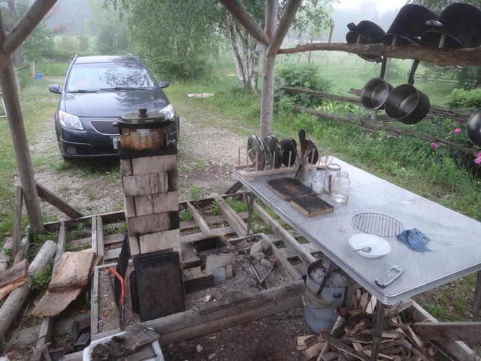 rocket stove outdoor kitchen with work surface and hanging rack
