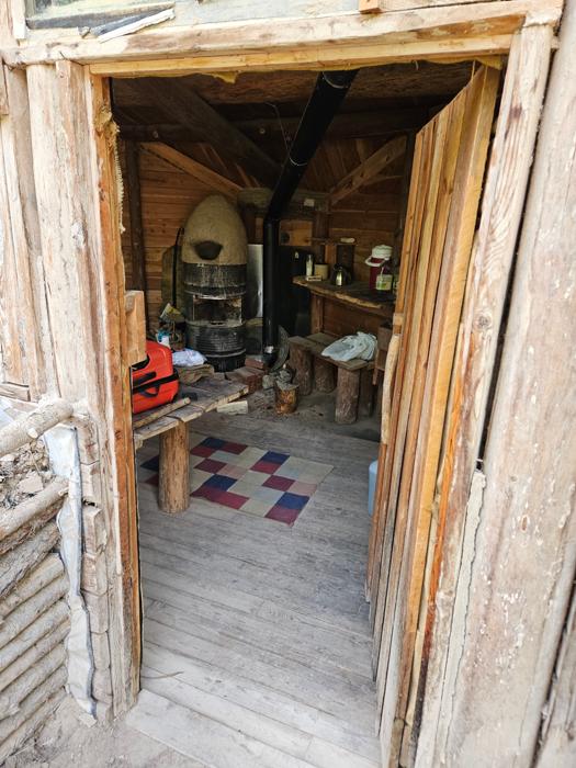 The front door of the dogstar earth sheltered house with a cobhat on a cottage rocket and some shelves