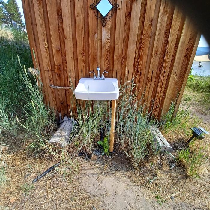 The sink attached to the shower shack, it might have hot water when the rocket water heater is running