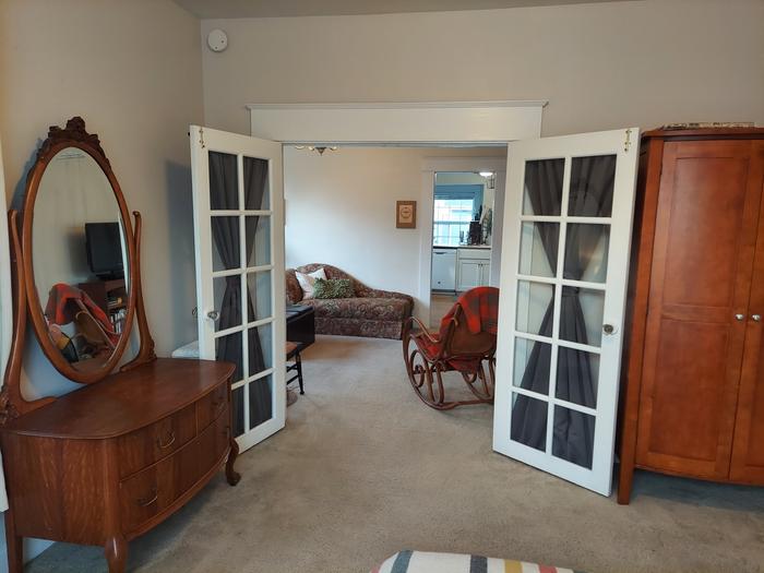 den French doors with blackout curtains that open to living room