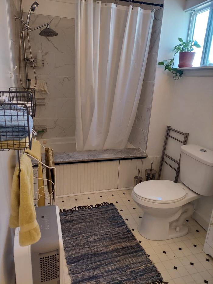 bathroom with deep soaking tub and recently upgraded shower tiles