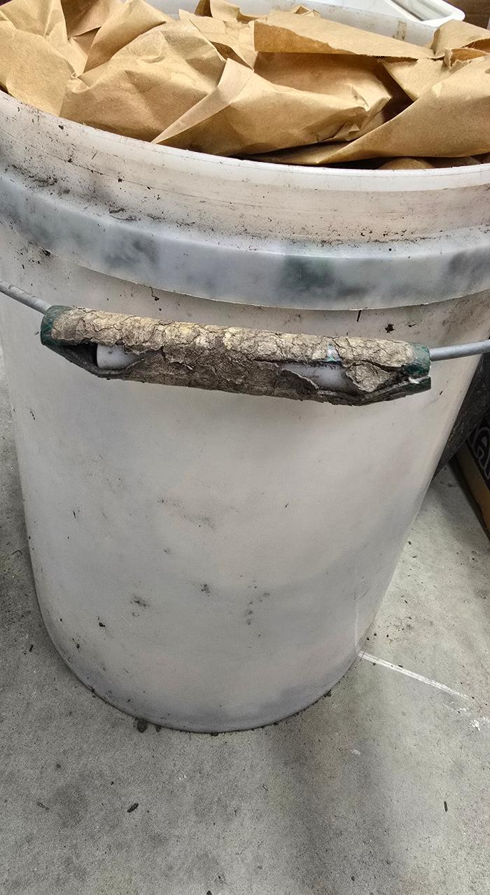 Split hosepipe wrapped in masking tape as bucket handle