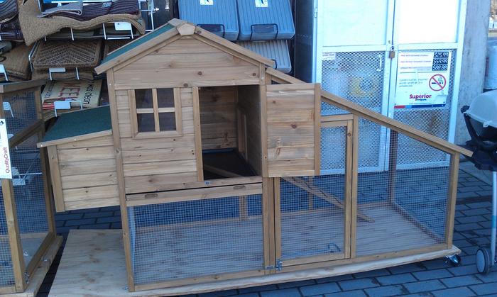 These chicken tractors are for sale at the Home Hardware along a busy street.