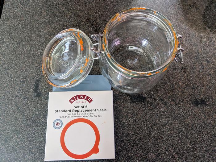 Kilner glass top closure jar, with degraded orange goo around it, and new replacement O-Ring package