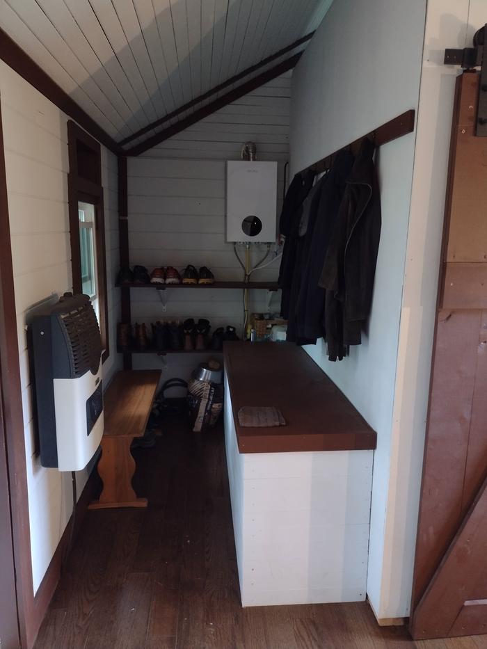 Mudroom with shelving, Martin DV1200 Direct Vent Heater, Velpax on-demand water heater, Flojet DC/AC water pump, and 100-gallon food-grade enclosed water tank