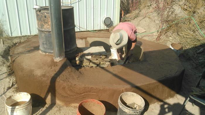 working on the plastered bench of the circle rocket mass heater