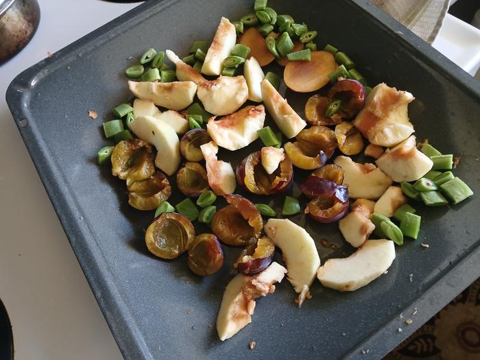 fresh apples, plums and beans cut up in a tray