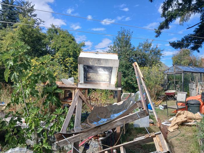 oven and parabolic mirror set up outside for dehydrating food