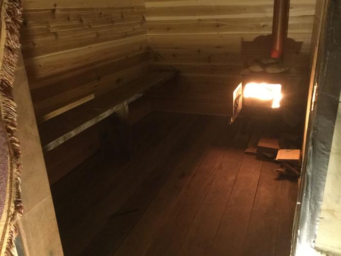 a fire in the woodstove of a sauna