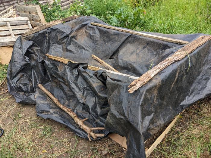 Composting bay covered in recovered black plastic
