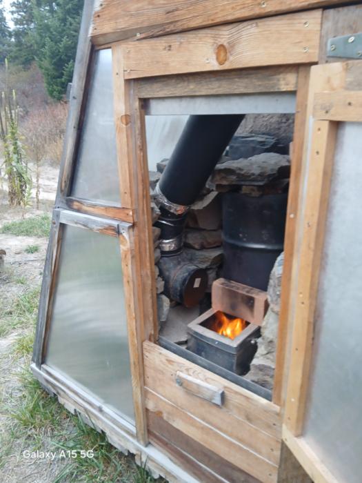 a fire roars in the rocket boosted solar food dryer