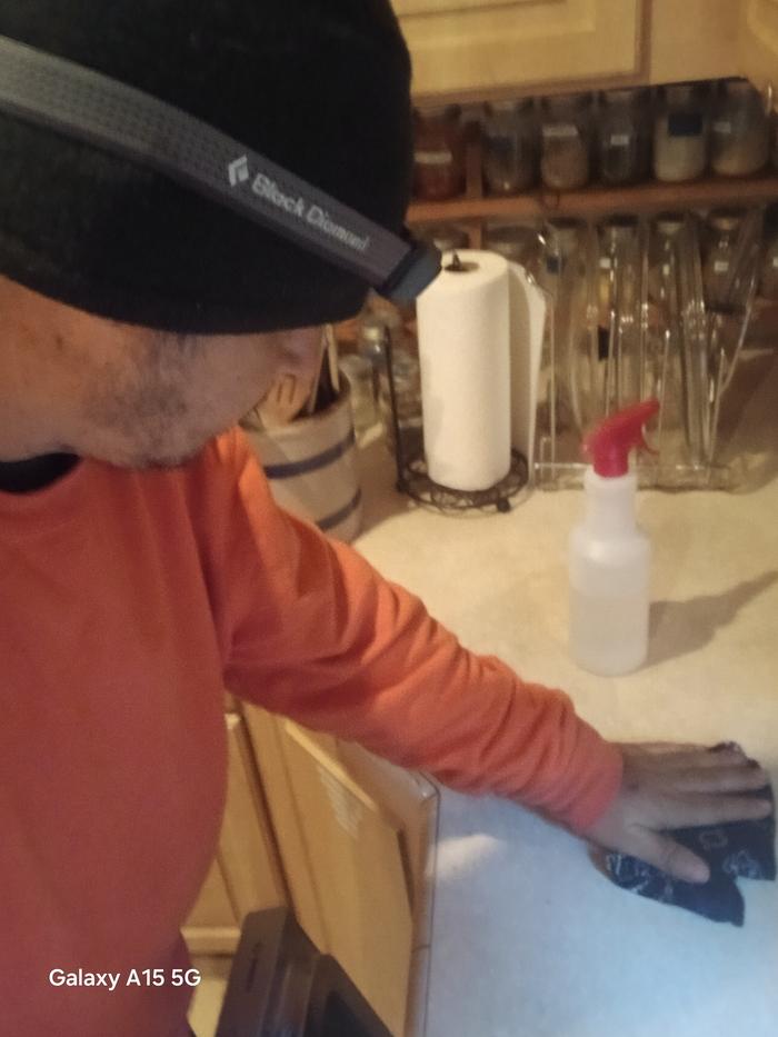 Esteban using an edible cleaner to clean the kitchen counters