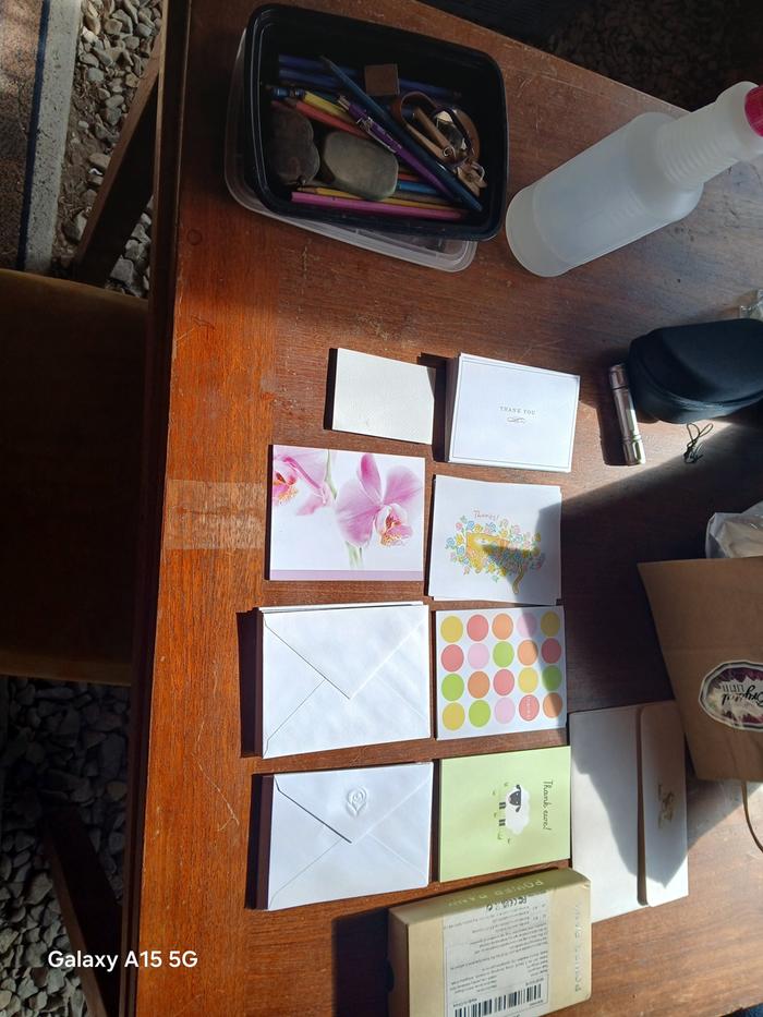 a bunch of cards and stationary on a wood table