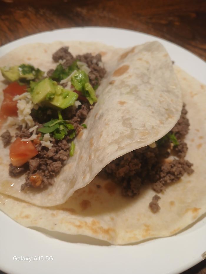 two tacos with avocado and fresh tomatoes