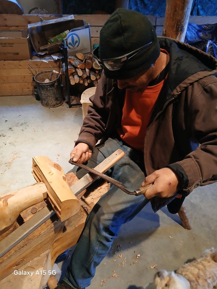 Esteban smooths a piece of wood to be used as a wheelbarrow handle