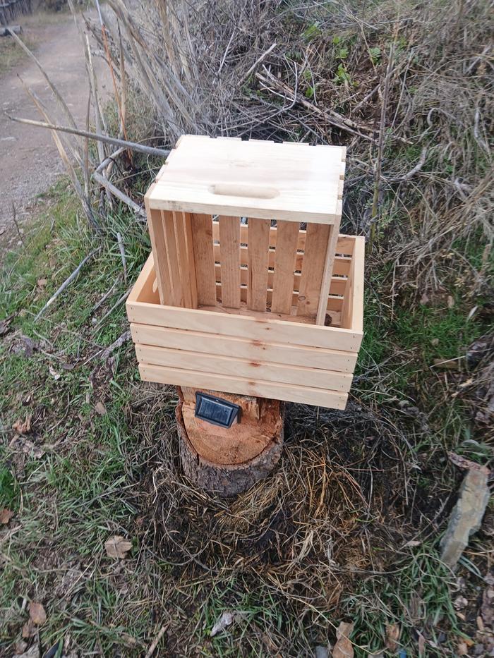 Two wooden crates sitting on a solar light outside