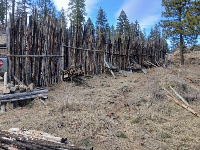 a finished junkpole fence with some charred pieces