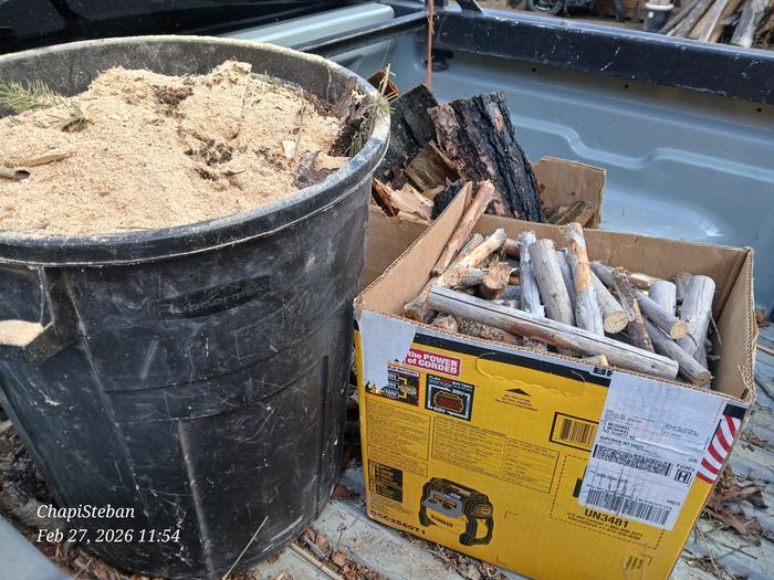a garbage can full of sawdust and cardboard boxes with woody bits in the back of a truck