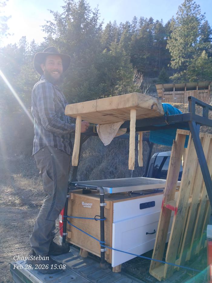 Harry lifts a wood table into the back of a pickup
