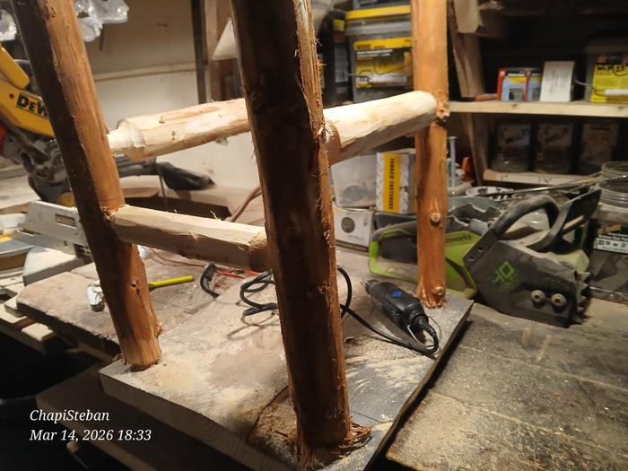 the structure of an end table with the head of an electric chainsaw in the background