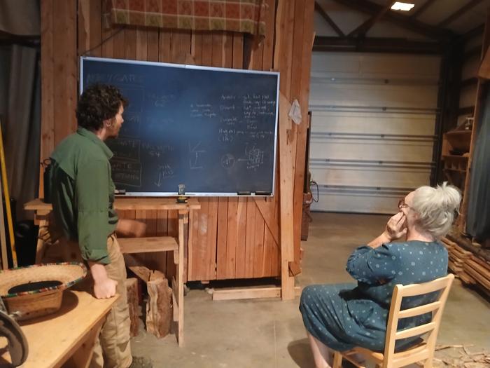 Leo going over firewood rack plans with Melissa 