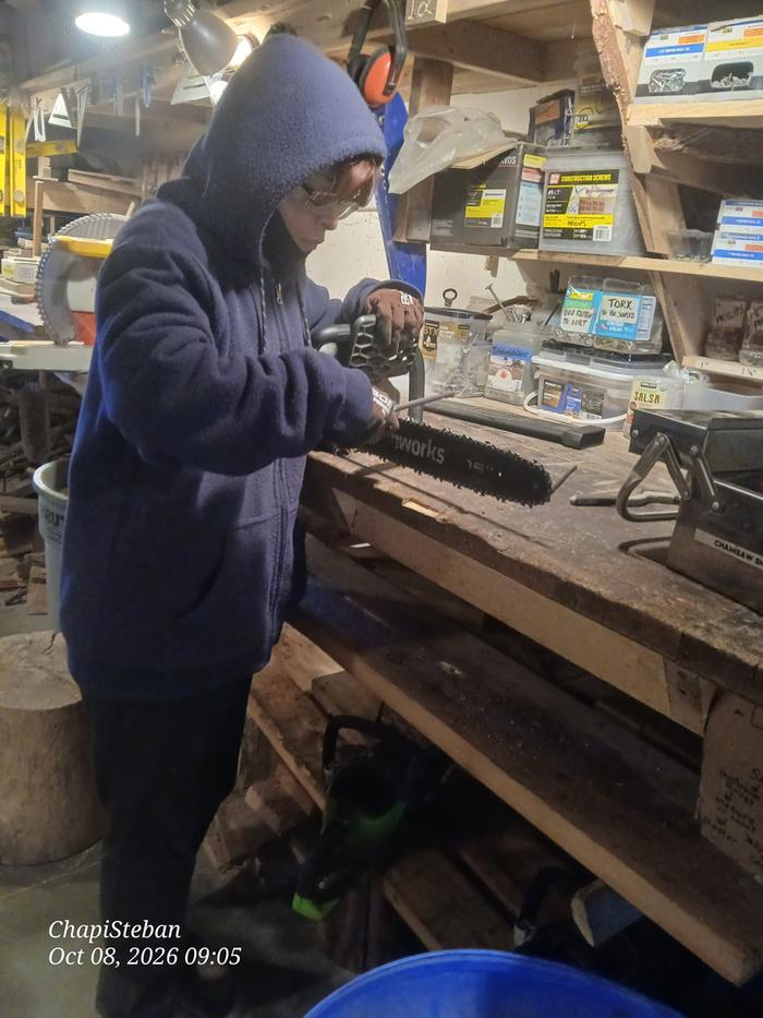 Jesse touching up her favorite chainsaw before the house paddock task 