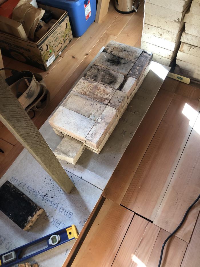 tileboard on top of a wood floor with firebricks laid on top of them