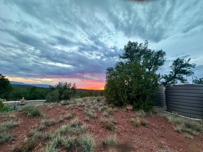 Water tanks on hill above house at sunset