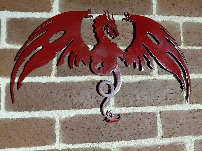 A sillouhette of a red dragon made from metal