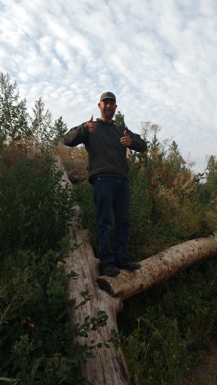 man standing on the log tab and slot to make it stay