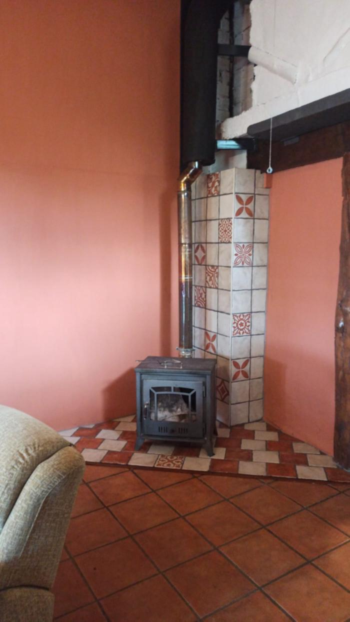 a mini stove in a tiled corner