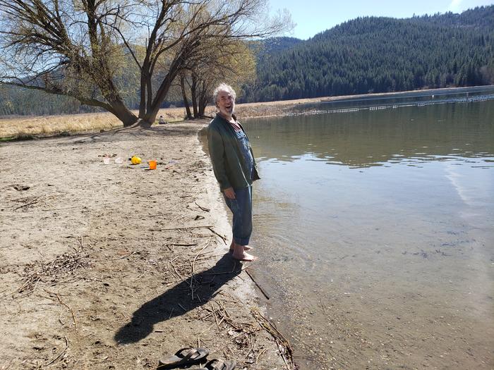 Paul dipping his feet in the lake
