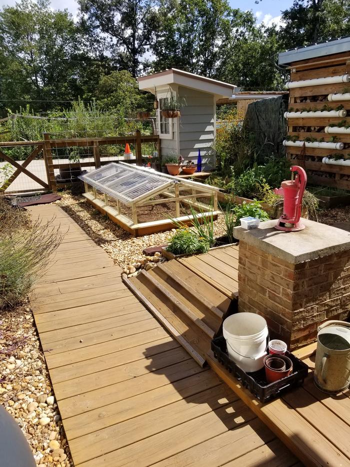 Kitchen garden with red pitcher pump just above the 3000 gal below grade concrete tank.