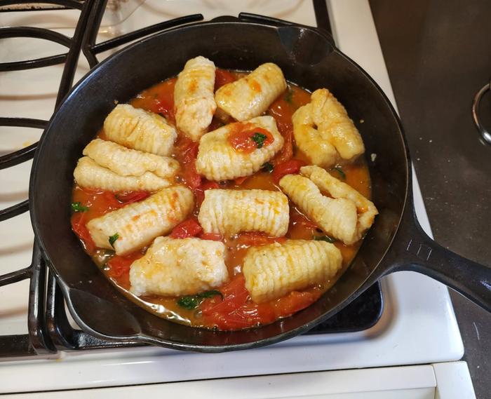 Ricotta Gnocchi in a skillet of tomato sauce