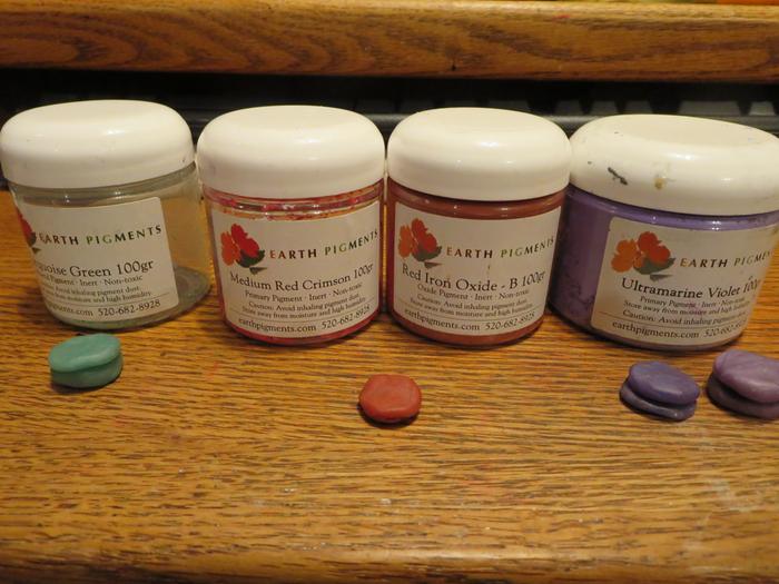 The colored sealing wax made with encaustic medium, and the pigments I used to color them. There in pairs to later sandwich around string.