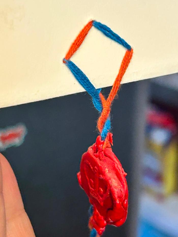 Here's a seal pendant I made years ago, using modern sealing wax that you have to melt with a candle. You have to sandwich the wax around the string.