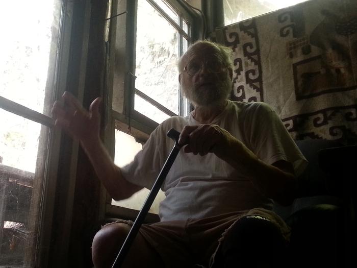 Mike in his original underground house (uphill patio in background)